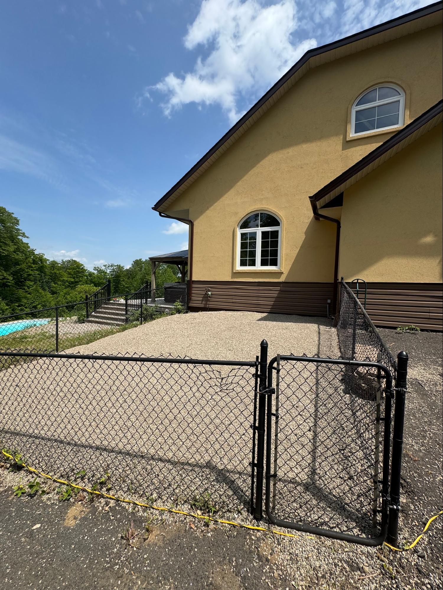 Gravel driveway with chain-link fence installation