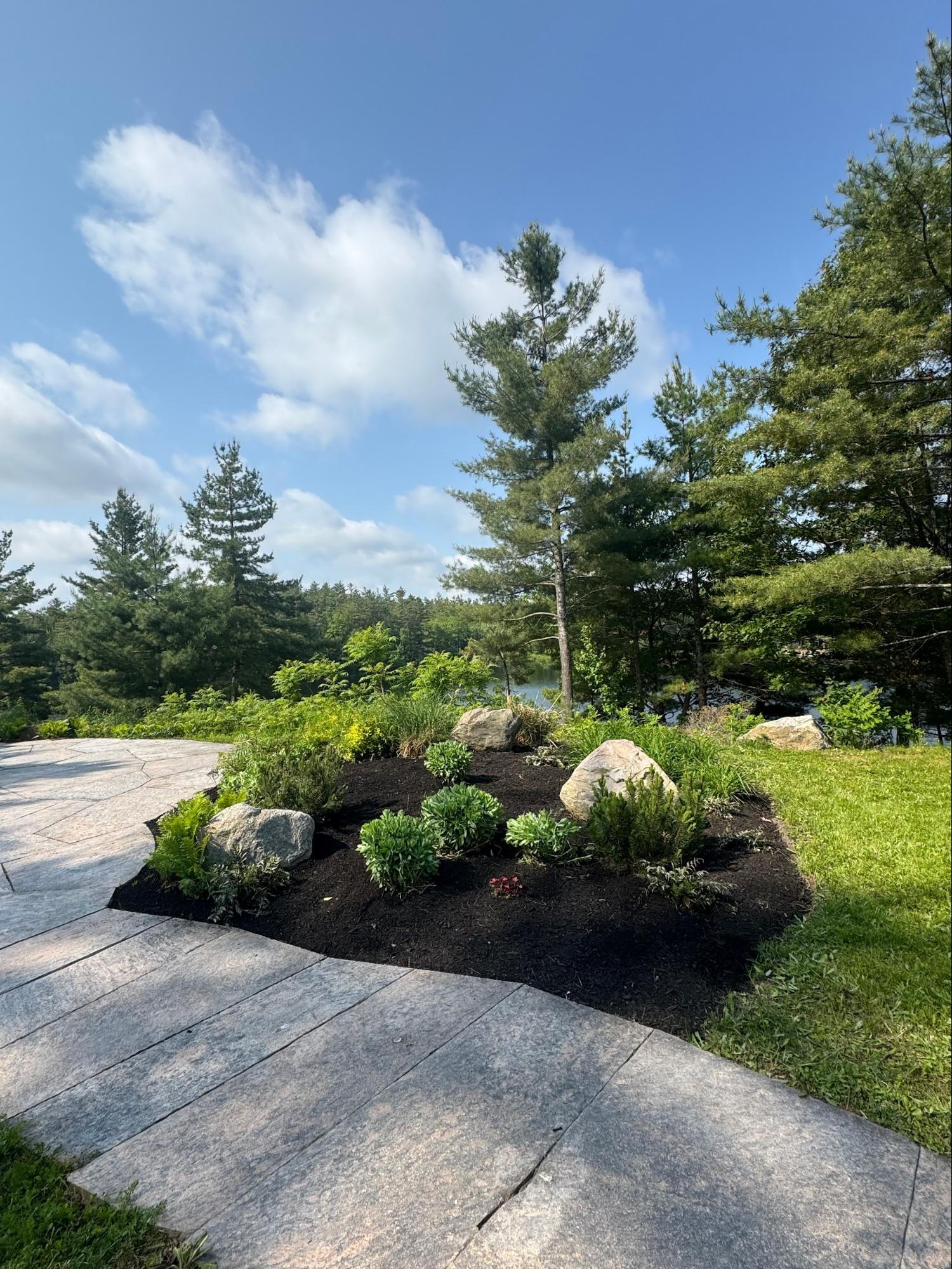 Landscaping bed with boulders and stone patio