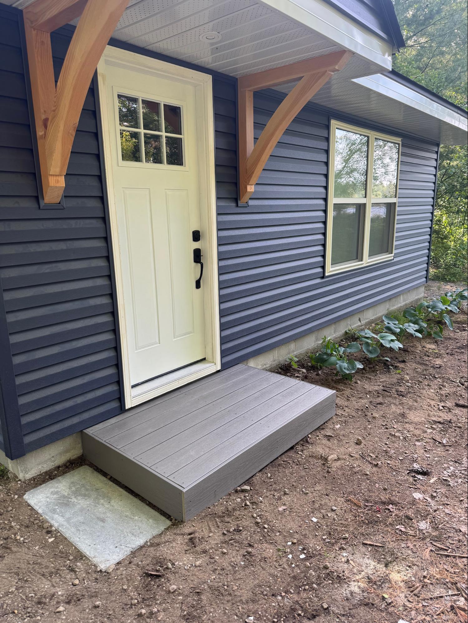 Cottage exterior with timber brackets and composite step
