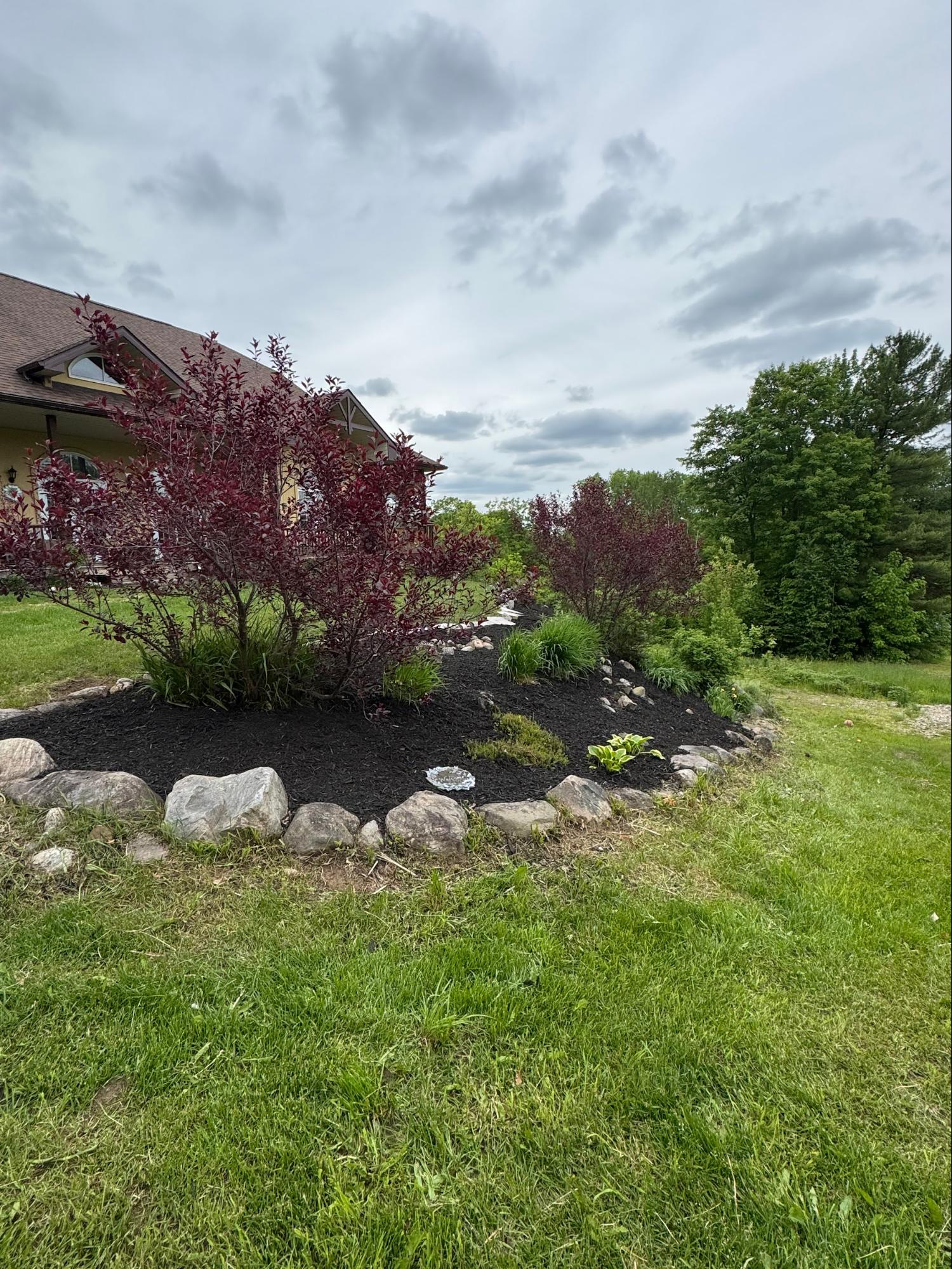 Boulder-edged landscaping bed with shrubs